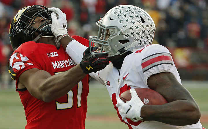 Ohio State tight end Rashod Berry (13) tries to get away from Maryland linebacker Nnamdi Egbuaba (31) after making a catch on fourth down in overtime at Capital One Field at Maryland Stadium in College Park, Maryland.  (Kyle Robertson / The Columbus Dispatch)